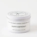 Jar of Coconut Candle Company Happy Birthday Candle with minimalist label next to birthday decor