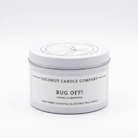 Lit natural coconut wax bug repellent candle burning cleanly on an outdoor patio table