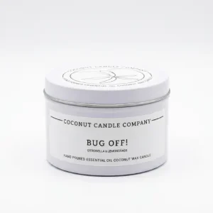 Lit natural coconut wax bug repellent candle burning cleanly on an outdoor patio table