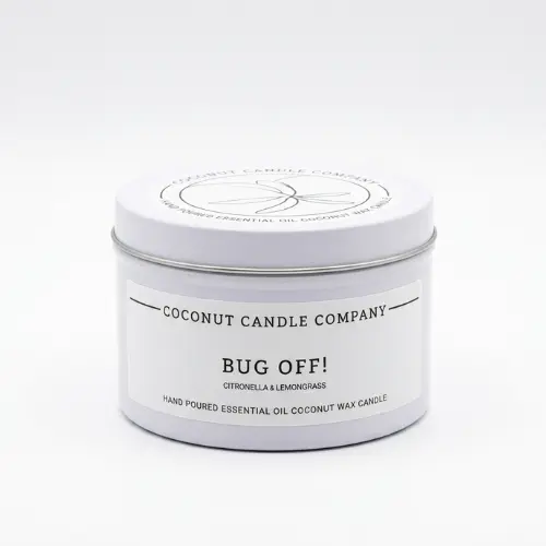 Lit natural coconut wax bug repellent candle burning cleanly on an outdoor patio table