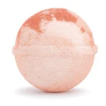 Shimmering orange and vanilla cocktail bomb fizzing in sparkling water with edible glitter