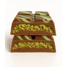 Close-up of a broken Astro Snacks Dubai Chocolate Bar showing the green pistachio and kataifi filling against a pure white background