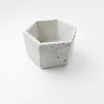 Hand-cast hexagonal Roman concrete planter with natural beeswax finish on white background
